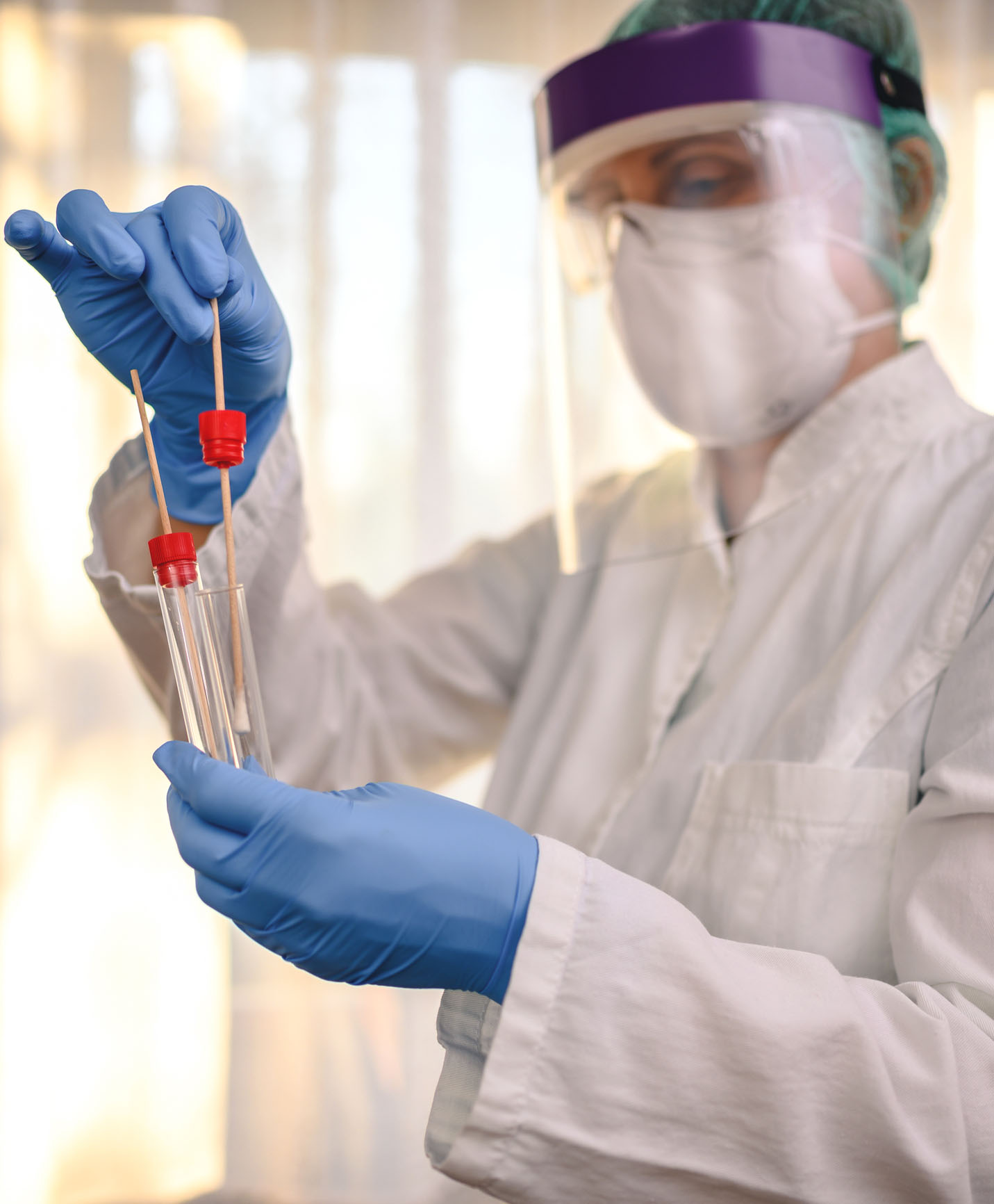 Healthcare professional holding tube test and sampling swab